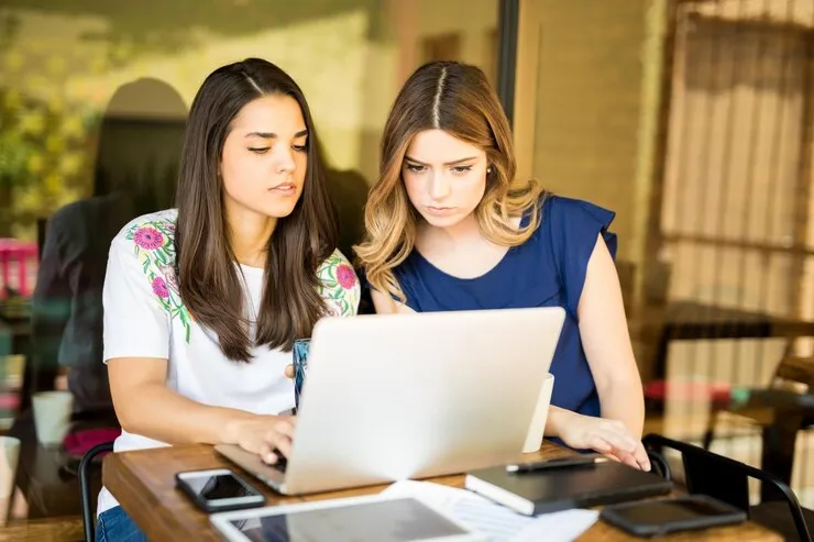 Two team members working together on a laptop